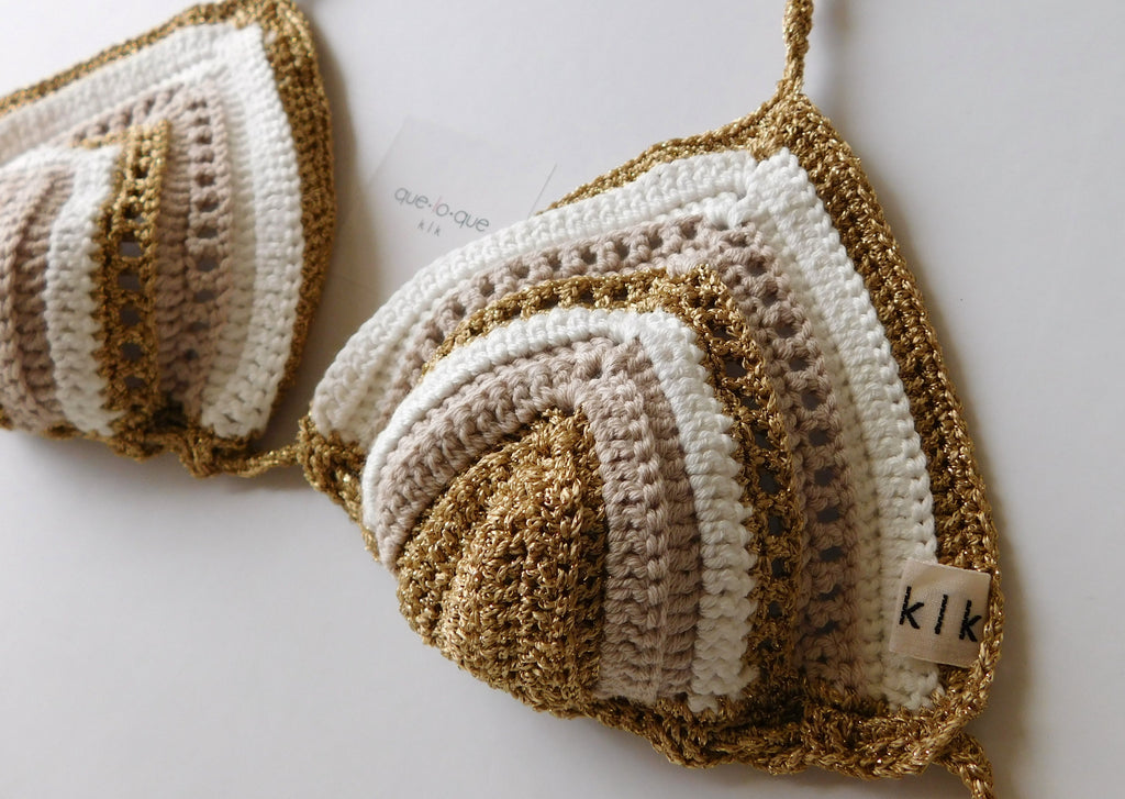Reggiseno di un costume in cotone all'uncinetto bianco, oro, beige di que lo que